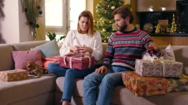 Bengal kedisine sahip beyaz bir aile, aile üyeleri ve arkadaşları için Noel hediyesi paketliyor. Boks günü. Çift.
