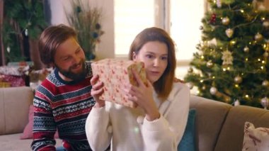 Sakallı beyaz adam sevgilisini mutlu ediyor. Noel hediyesi veriyor. Evde Noel 'de boks günü hediyelerini değiştiriyor..