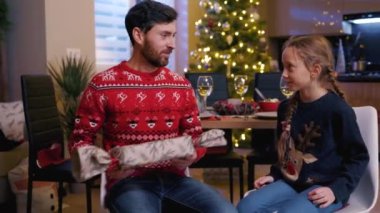 Genç kız için güzel bir hediye hazırlayan yakışıklı bir baba Noel partisini tüm aile içinde kutluyor..