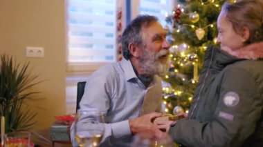 Neşeli, harika bir genç kız büyükbabaya güzel bir hediye kutusunda sürpriz yapıyor. Noel ağacı. Noel arkaplanı. Aile kış tatilini kutluyor.