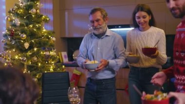 Beyaz bir aile Noel arifesinde masada oturuyor. Güzel mutlu ebeveynler, büyükbaba ve iki çocuk Noel yemeğini birlikte kutluyorlar..