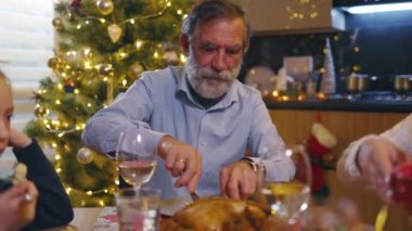 Dedesi ve iki çocuğu olan güzel bir aile Noel arifesini evde kutsal yemeği kutlayarak geçiriyorlar. Aşk, ilişki ve destek kavramı.