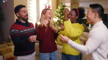 Komik çok ırklı arkadaşların Noel 'de yanan maytaplarla gülüşleri oluyor. Mutlu ol. Geleneksel tatil. Kutlama. Mutlu noeller. Kış zamanı. Yavaş çekim