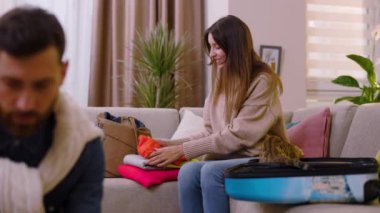 Çekici bir aile, kıyafetlerini seyahat çantasına koyar. Sınıfta beş tane ver. Gülümseyerek mutlu ol. Kızı ebeveynlerine yardım ediyor. Turizm çifti macera yaşam tarzı. Yavaş çekim