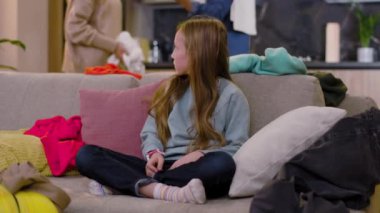 Kameranın omuzlarını silkeleyen üzgün küçük kız. Arka planda anne ve babası kavga eder. Evde kıyafet sorunları ve şiddet yaşarlar. Yavaş çekim