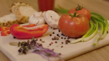 Sebzeleri ahşap bir tahtada kapat. Domates soğanlı mikroyeşil. Taze, sağlıklı yiyecekler. Çiğ. Yavaş çekim