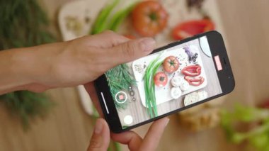 Gıda blogcusu kadın elleri ahşap masada sebzeli pano videosu çekiyor. Yemek fotoğrafı. Vejetaryen blogunda yemek. Kapatın. Yavaş çekim