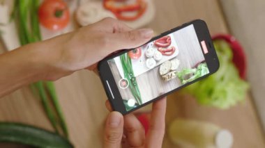 Genç blogcu kadın elleriyle tahta üzerinde sebze olan bir panonun videosunu çekiyor. Yemek fotoğrafı. Vejetaryen blogunda yemek. Kapatın. Yavaş çekim