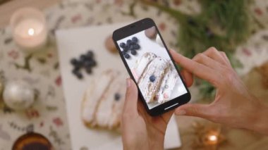 Ellerini kapat kadın, telefonu tut ve lezzetli tatlıların fotoğrafını çek. Noel zamanı. Blog yazarı mutfak tabağı. Yavaş çekim