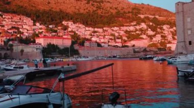 Deniz kanalında güzel pembe panoramik manzara ve günbatımında eski kasaba O. Su tarihi mimari tekne inşaatı. Yavaş çekim