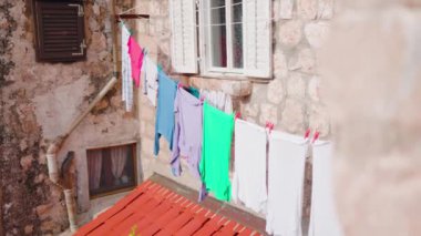 Eski şehirde eski bir binanın penceresinden rüzgarla taşınan giysiler asılıydı. Mimarlık binası sokağı geleneksel seyahat şehri. Yavaş çekim