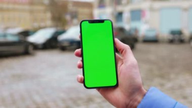 Dikey yeşil ekran arka plan sokak şehri açık havada internet krom bulanıklığı olan bir telefon kullanırken çekilmiş. Cep telefonu medya aygıtı modern hücresel. Yavaş çekim