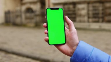 Dikey yeşil ekran arka plan sokak şehri açık havada internet krom bulanıklığı olan bir telefon kullanan vurulan bir adam. Cep telefonu medya aygıtı modern hücresel. Yavaş çekim