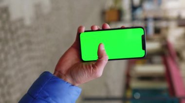 Yeşil ekran akıllı telefonlu bir adamın sokakta el ele tutuşup dolaşırken görüntüsü. Yavaş çekim