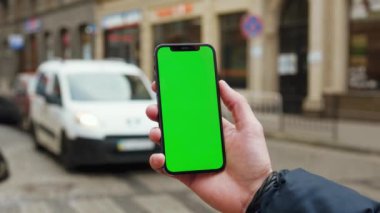 Dikey yeşil ekran arka planlı araba kullanan eller sokak şehri açık havada internet krom bulanıklaştırdı. Cep telefonu medya aygıtı. Kapatın. Yavaş çekim