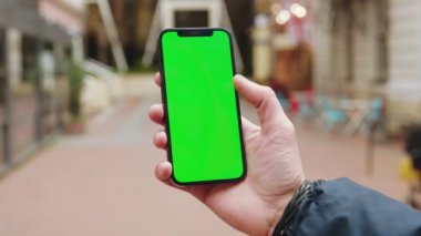 Dikey yeşil ekran arka plan teras kenti açık havada internet krom bulanıklığı olan bir telefon kullanarak ellerini kapat. Cep telefonu medya aygıtı. Yavaş çekim