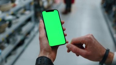 Eller arka plan bulanık insanlarda dikey yeşil ekranlı cep telefonu kullanır. Model dinleme görüntülü kromakey telefon. Yavaş çekim