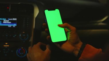 Geceleri arabada dikey yeşil ekranlı el kameraları kullanılıyor. Cihaz dijital cihaz, dokunmatik ekranlı mobil telefon teknolojisi. Kapatın. Yavaş çekim