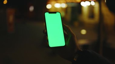 Kapat ellerini adamım, gece lambasında pembe arka planda dikey yeşil ekranlı telefon kullan akşam akıllı telefon ekran uygulaması. Teknoloji dokunmatik hücre ekranı. Yavaş çekim