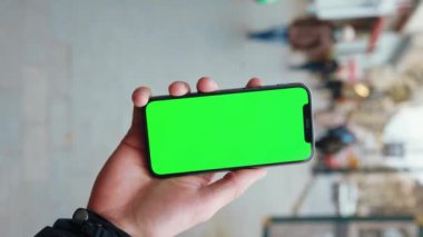 NEW YORK - 19 Aralık 2020: Arka planda yeşil ekranlı telefonlara dokunan akıllı adam sokak mesajını yürütür. İş aleti dijital. Yavaş çekim