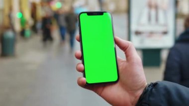 NEW YORK - 19 Aralık 2020: Telefon kullanan sokak işçileri üzerinde dikey yeşil ekran arka planlı insanlar şehrin açık havada bulanık internet krom yürür. Cep telefonu medya aygıtı. Yavaş çekim