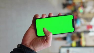 NEW YORK - 19 Aralık 2020: Arka planda yeşil ekranlı telefonlara dokunan akıllı adam sokak mesajını yürütür. İş aleti dijital. Yavaş çekim