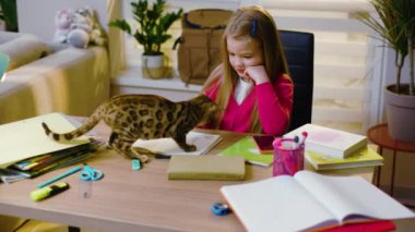 Modern bir apartman dairesinde, ev ödevi yaparak yazmayı öğreniyor. Kedi etrafta dolanıp kızla oynuyor. Anaokulu çocuğu tek başına ilkokul eğitimi alıyor. Yavaş çekim