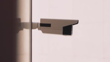 Beyaz arka plandaki güvenlik kamerası dışarıda kayıt yapıyor. Güvenlik kameraları. Mahremiyet, şehir, koruma, ev, sistem, kontrol, güvenlik, görüş, güvenlik, video. Yavaş çekim