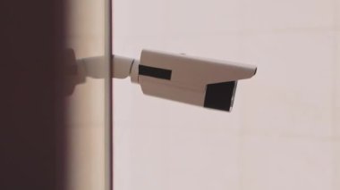 Güvenlik kamerasının beyaz arka planı olan bir binanın dışında kaydı çekerken görüntüsü. Güvenlik kameraları. Mahremiyet, şehir, koruma, ev, sistem, kontrol, güvenlik, görüş, güvenlik, video. Yavaş çekim