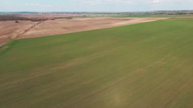 Kıştan sonraki hasat tarlasının güzel manzarasını kapatın. Kırsal, tarım, manzara, doğa, seyahat, güneş, buğday, tarım, manzara. Havadan. Helikopter görüntüsü. Yavaş çekim