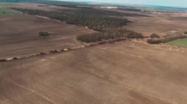 Kış sonrası hasat tarlasının hava görüntüsü. Kırsal, tarım, manzara, doğa, seyahat, güneş, buğday, tarım, manzara. Helikopter görüntüsü. Yavaş çekim
