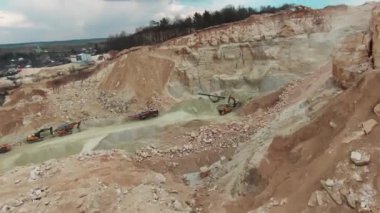 Taş ocağının yavaş çekim görüntüsü. Kazıcı, ekipman, maden tozu, açık, kamyon, açılış, tehlike, endüstri, dron, metal, iş, çukur, taş, helikopter, inşaat. Kapat.