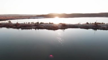 Gün batımında muhteşem manzaranın üzerinde uçan dron 'dan hava manzarası. Helikopter nehir manzarasında terk edilmiş eski bir bakır şantiyesinin üzerinde uçuyor..