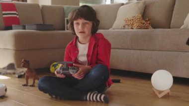 Kafkas çocuk uzaktan kumandayla uzaktan kumandayla oyuncak helikopter uçuruyor oturma odasında teknolojiyle oynuyor. Ev eğlencesi. Çocuklar.