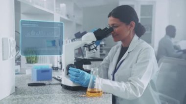 Kendini işine adamış bir kadın bilim adamı yüksek teknolojili bir laboratuvarda mikroskop altında araştırma ve yeniliğin karışımını gösteren örnekler inceliyor..