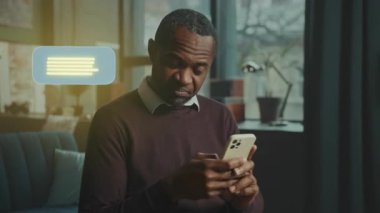 Bir adam akıllı telefonuyla iletişim kuruyor, kapalı bir ortamda mesaj atmaktan zevk alıyor, modern iletişim ve bağlantı gösteriyor..