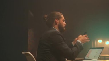 Renkli notlarla dolu bir duvarla stüdyoda beyaz yaratıcı grafikler ve dizüstü bilgisayarlar, kampanya planlarken el kol hareketi.