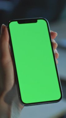 Gece vardiyası çalışanı akıllı telefonu tutuyor. Siyah iş adamı CEO yeşil ekrandaki ekomünikasyon büyümesini izliyor.