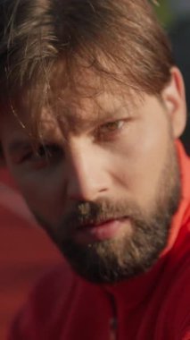 Beyaz adam yakından bakıyor. Ter içinde. Burun sakalı, güneş ışığı, cilt kameramanı.