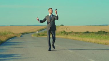 Beyaz adam telefonda konuşuyor, yolda el kol hareketi yapıyor, özel dikim takım elbise, altın tarlalar, ikna edici vücut dili.,