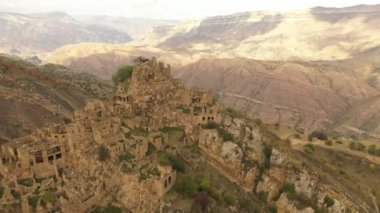 Gamsutl köyü, dağlarda terk edilmiş. Zaptedilemez tepe kalesi. Hayalet kasaba, eski bir yerleşim yerinin kalıntıları. Dağıstan dağlarındaki terk edilmiş eski bir köyün 4k hava manzarası