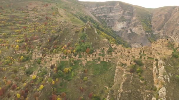 Verlaten in de bergen, het dorp Gamsutl. Onneembare vesting op een heuveltop. Ghost Town, ruïnes van een oude nederzetting. 4k uitzicht vanuit de lucht op een oud verlaten dorp in het Dagestan gebergte — Stockvideo