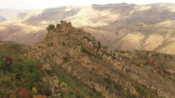 Gamsutl köyü, dağlarda terk edilmiş. Zaptedilemez tepe kalesi. Hayalet kasaba, eski bir yerleşim yerinin kalıntıları. Dağıstan dağlarındaki terk edilmiş eski bir köyün 4k hava manzarası — Stok video