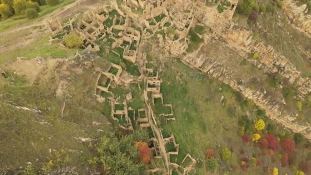 Abandonada nas montanhas, a aldeia de Gamsutl. Fortaleza impenetrável no topo da colina. Cidade fantasma, ruínas de um antigo povoado. 4k vista aérea de uma antiga aldeia abandonada nas montanhas do Daguestão — Vídeo de Stock