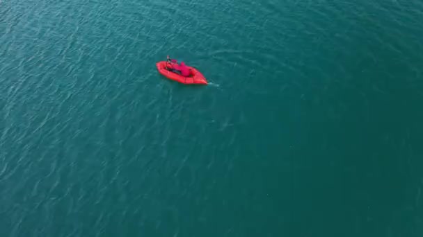 Packraft, jangada leve de uma pessoa usada para expedição ou corrida de aventura em um lago, passeio de barco inflável em um lago de montanha. 4k vista aérea — Vídeo de Stock