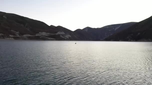 Packraft, jangada leve de uma pessoa usada para expedição ou corrida de aventura em um lago, passeio de barco inflável em um lago de montanha. 4k vista aérea — Vídeo de Stock