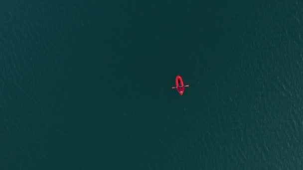 探検やアドベンチャーレースのために湖で使用されるパックラフト、 1人の軽量いかだは、山の湖で膨脹可能なボートに乗る。4k空中ビュー — ストック動画