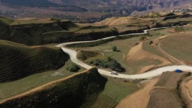 Dağıstan yolları. Dağ yolunda giden arabanın hava görüntüsü. Güzel dağ yolu. Bir dağ yolu boyunca araba sürüyoruz. Yolculuk. Dağ manzarası