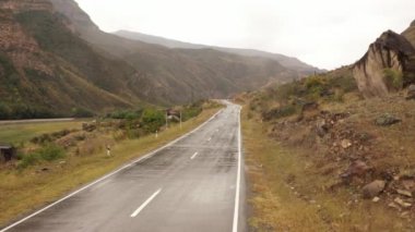 Dağıstan yolları. Dağ yolunda giden arabanın hava görüntüsü. Güzel dağ yolu. Bir dağ yolu boyunca araba sürüyoruz. Yolculuk. Dağ manzarası