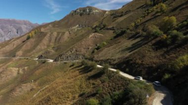 Dağıstan yolları. Dağ yolunda giden arabanın hava görüntüsü. Güzel dağ yolu. Bir dağ yolu boyunca araba sürüyoruz. Yolculuk. Dağ manzarası